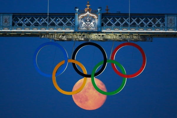 Luna plină se ridică printre inele olimpice